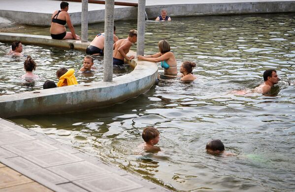 Люди купаются на Аушигерских термальных источниках в Кабардино-Балкарии