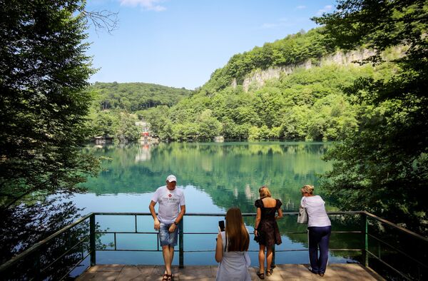 Туристы около Нижнего Голубого озера в Черекском ущелье в Кабардино-Балкарии