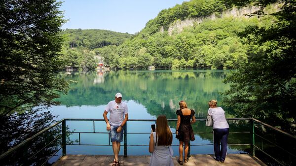 Туристы около Нижнего Голубого озера в Черекском ущелье в Кабардино-Балкарии