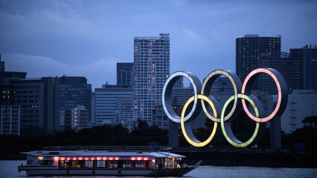 A Japanese houseboat, also known as yakatabune, sails past the Olympic Rings as seen from Odaiba Seaside Park in Tokyo on July 12, 2020. (Photo by Philip FONG / AFP)