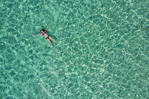 Аэрофотоснимок женщины в море на пляже небольшого острова Хриси, к югу от Крита. Греция