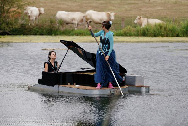 Пианист Сесиль Ваутерс и певица Эвелин Зоу выступают на озере во время репетиции своего шоу в Риккебурге, Франция