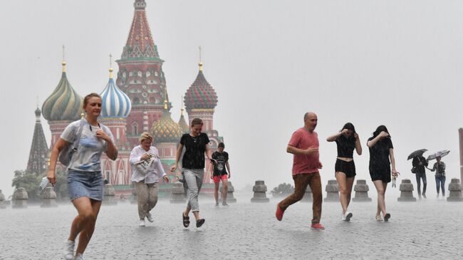 Люди во время дождя на Красной площади в Москве