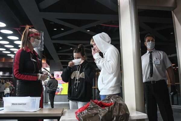 Зрители надевают защитные маски на входе в кинотеатр Каро 11 Октябрь в Москве