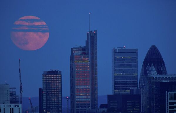 Полная луна над финансовым районом лондонского Сити в Великобритании