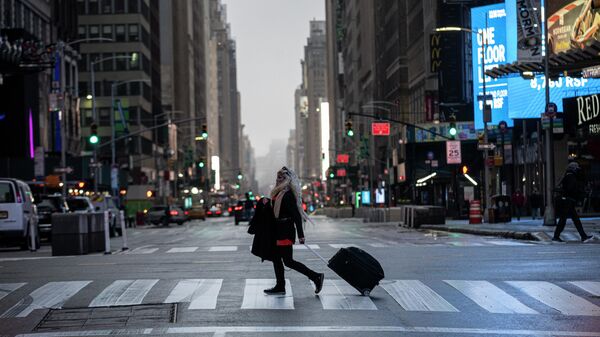 Девушка с чемоданом на Таймс-сквер в Нью-Йорке во время пандемии коронавируса