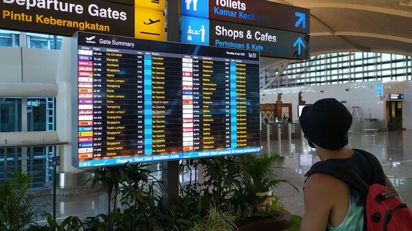 Табло в аэропорту Денпасара с информацией о рейсах, Индонезия