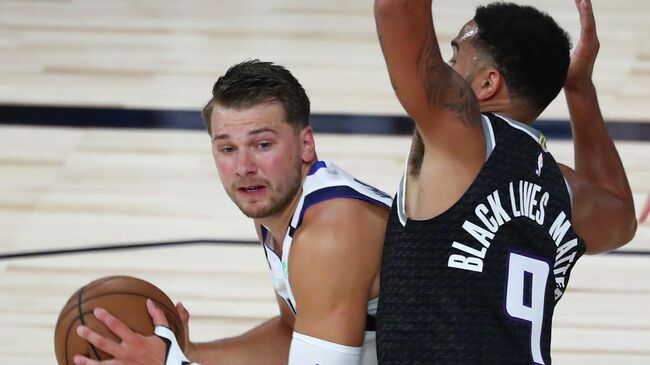 LAKE BUENA VISTA, FLORIDA - AUGUST 04: Dallas Mavericks guard Luka Doncic #77 tries to pass the ball against Sacramento Kings guard Cory Joseph #9 during the first half of an NBA basketball game at HP Field House at ESPN Wide World Of Sports Complex on August 4, 2020 in Lake Buena Vista, Florida. NOTE TO USER: User expressly acknowledges and agrees that, by downloading and or using this photograph, User is consenting to the terms and conditions of the Getty Images License Agreement.   Kim Klement-Pool/Getty Images/AFP