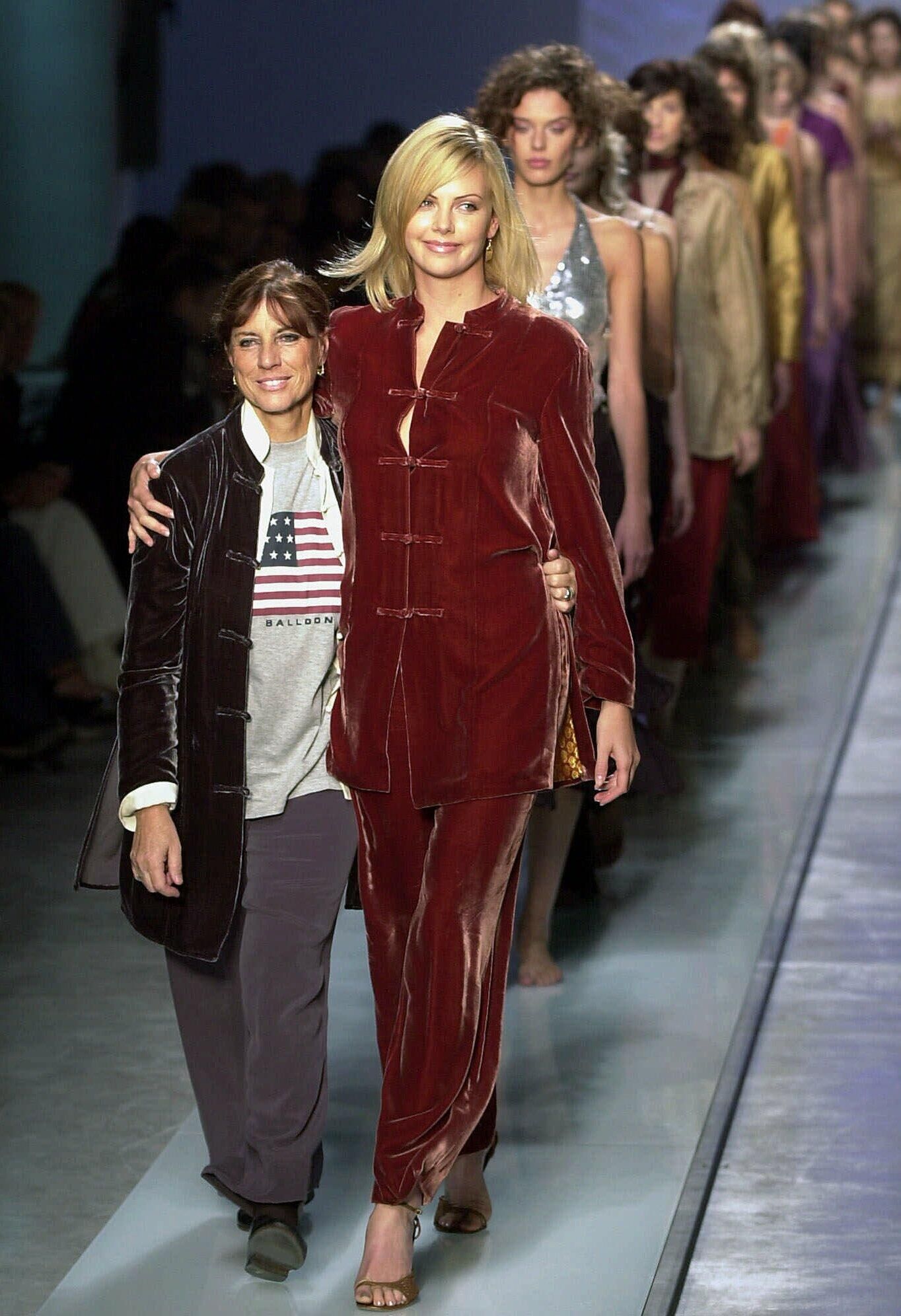 Шарлиз Терон и итальянский модельер Bebi Greco на подиуме в конце показа коллекции Blunauta Spring-Summer 2002  в Милане, Италия. 26 сентября 2001 год - РИА Новости, 1920, 26.10.2025