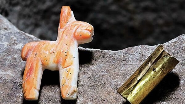 Статуэтка верблюда и свернутый лист золота, найденные у озера Титикака