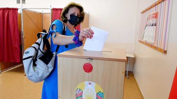 Девушка досрочно голосует на выборах президента Белоруссии на избирательном участке в Минске