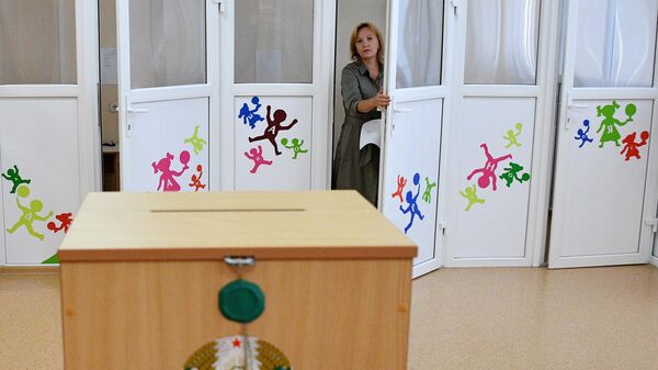 Женщина голосует на выборах президента Белоруссии на избирательном участке в Минске