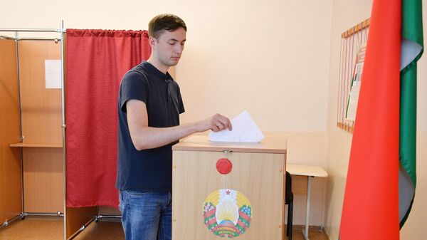  Молодой человек досрочно голосует на выборах президента Белоруссии на избирательном участке в Минске