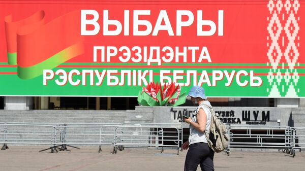 Женщина перед избирательным участком  на выборах президента Белоруссии в Минске