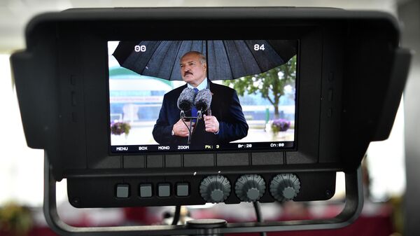Президент Белоруссии Александр Лукашенко на экране во время разговора со СМИ в Минске. 9 августа 2020