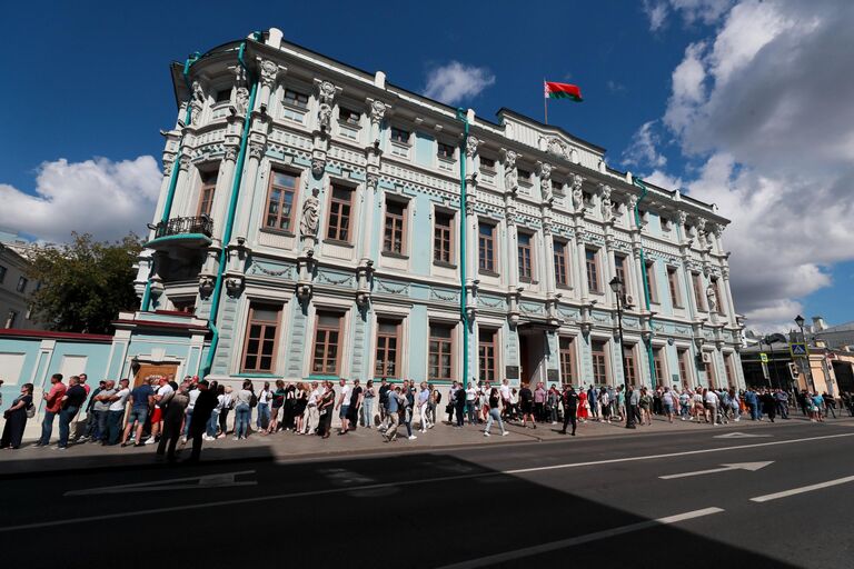 Люди стоят в очереди у здания посольства Белорусии в Москве во время голосования на выборах президента Белоруссии