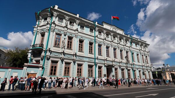 Люди стоят в очереди у здания посольства Белорусии в Москве во время голосования на выборах президента Белоруссии