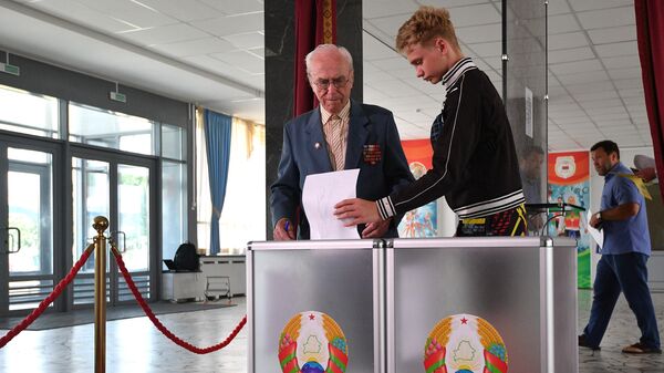 Люди голосуют на выборах президента Белоруссии на избирательном участке в Минске