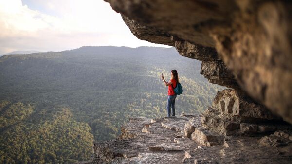 Девушка на смотровой площадке Орлиная полка, расположенной высоко на скалах, откуда открывается вид на Гуамское ущелье
