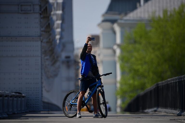 Велосипедист фотографируется на Крымском мосту