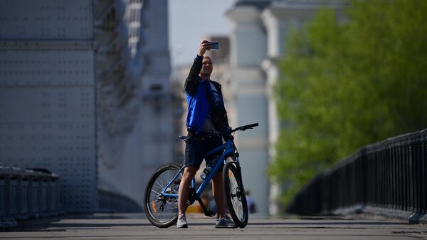 Велосипедист фотографируется на Крымском мосту