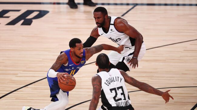 LAKE BUENA VISTA, FLORIDA - AUGUST 12: Monte Morris #11 of the Denver Nuggets drives between Patrick Patterson #54 and Lou Williams #23 of the LA Clippers in the fourth quarter at AdventHealth Arena at ESPN Wide World Of Sports Complex on August 12, 2020 in Lake Buena Vista, Florida. NOTE TO USER: User expressly acknowledges and agrees that, by downloading and or using this photograph, User is consenting to the terms and conditions of the Getty Images License Agreement.   Kim Klement-Pool/Getty Images/AFP