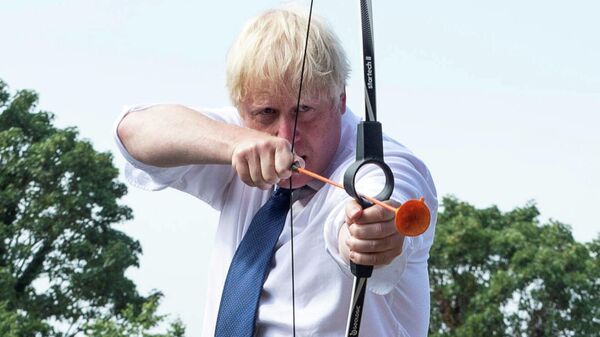 Премьер-министр Великобритании Борис Джонсон принимает участие в стрельбе из лука во время посещения летнего лагеря в Лондоне