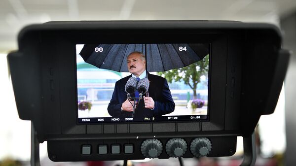 Президент Белоруссии Александр Лукашенко на экране во время разговора со СМИ в Минске. 9 августа 2020