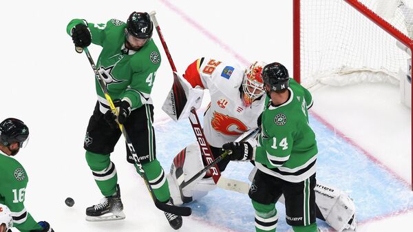 EDMONTON, ALBERTA - AUGUST 13: Cam Talbot #39 of the Calgary Flames defends the net against Alexander Radulov #47 and Jamie Benn #14 of the Dallas Stars in Game Two of the Western Conference First Round during the 2020 NHL Stanley Cup Playoffs at Rogers Place on August 13, 2020 in Edmonton, Alberta, Canada.   Jeff Vinnick/Getty Images/AFP