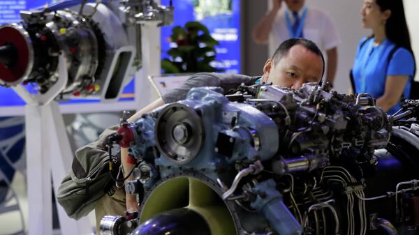 Мужчина рассматривает двигатель вертолета, разработанный компанией Мотор Сич, представленный на выставке Aviation Expo China в Пекине