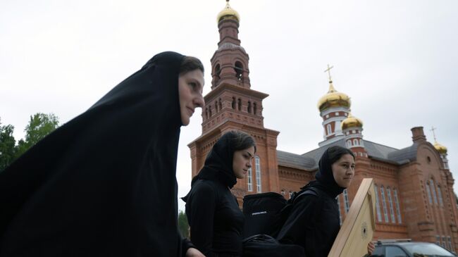 Монахини на территории Среднеуральского женского монастыря. Среднеуральский женский монастырь в честь иконы божией матери Спорительница хлебов, основателем которого является лишенный сана схиигумен Сергий 