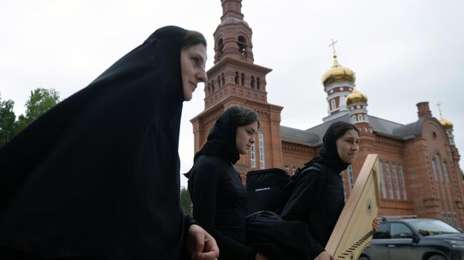 Монахини на территории Среднеуральского женского монастыря. Среднеуральский женский монастырь в честь иконы Божией Матери Спорительница хлебов, основателем которого является лишенный сана схиигумен Сергий 