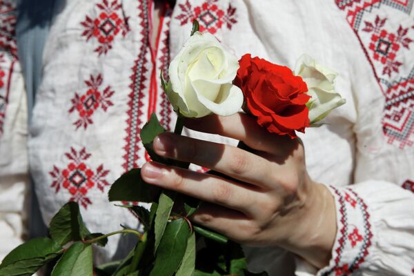 Женщина держит розы во время митинга в поддержку белорусской оппозиции в центре Киева