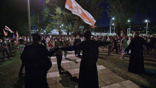 Волонтеры пытаются остановить колонну протестующих, направляющихся к изолятору на улице Окрестина в Минске