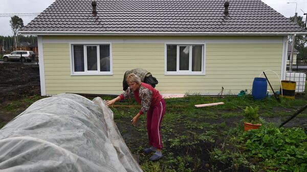 Местная жительница Татьяна Долгих во дворе нового дома в микрорайоне Березовая роща в городе Тулун Иркутской области.
