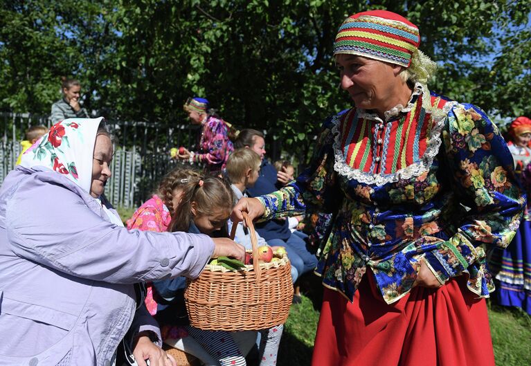 Участники музейно-фольклорного праздника Яблочной Спас в Красновидово угощают зрителей яблоками на территории села Красновидово Камско-Устьинского района Республики Татарстан