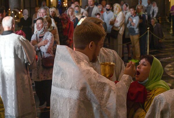 Верующие причащаются на праздничном богослужении в честь Преображения Господня в Казанском соборе в Санкт-Петербурге