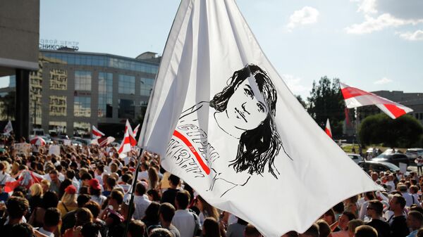 Люди держат флаг с портретом Светланы Тихановской в Минске 