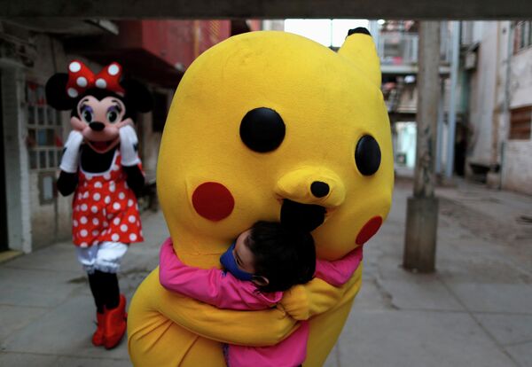 Человек в костюме Пикачу обнимает ребенка во время Дня защиты детей в Буэнос-Айресе, Аргентина