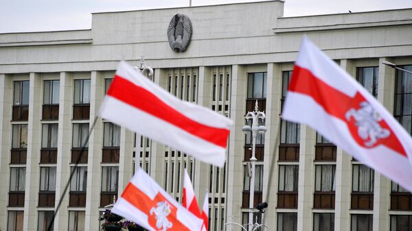 Флаги участников акции протеста на фоне Дома правительства на площади Независимости в Минске
