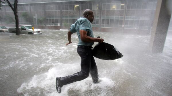 Мужчина бежит к стадиону Супердоум во время урагана Катрина в Новом Орлеане
