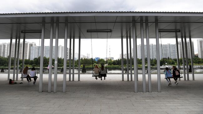 Девушки качаются на качелях в парке 850-летия Москвы