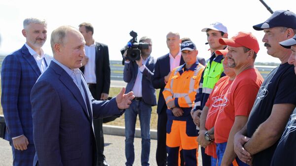 Президент РФ Владимир Путин беседует с дорожниками, которые принимали участие в строительстве, на церемонии запуска движения по трассе Таврида в Крыму