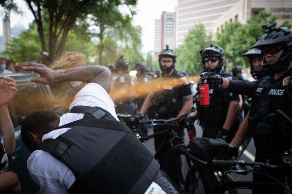 Сотрудник полиции распыляет на протестующих перцовый баллончик в Шарлотте, штат Северная Каролина