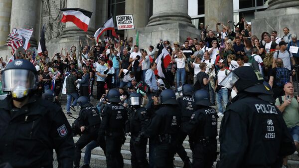 Полицейские перед зданием Рейхстага во время митинга против правительственных ограничений после вспышки COVID-19 в Берлине, Германия