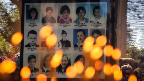 Свечи и игрушки у фотографий погибших в помещении бывшей Бесланской школы №1