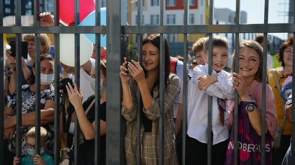 Родители наблюдают за праздничной линейкой в школе No215 Созвездие в микрорайоне Солнечный в Екатеринбурге в День знаний