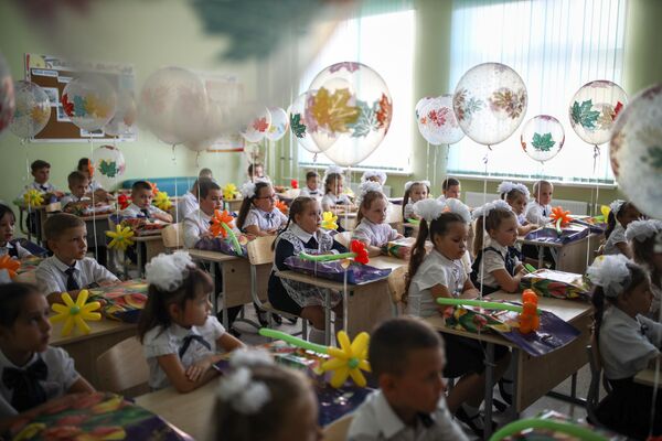 Первоклассники сидят за партой в классе в школе №71 в День знаний в Краснодаре