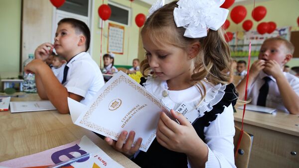 Первоклассники сидят за партой в классе в школе №71 в День знаний в Краснодаре