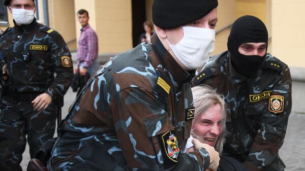 Сотрудники правоохранительных органов задерживают участника акции протеста в Минске